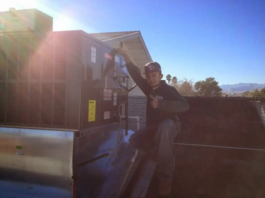 HVAC technician performing Air Duct Cleaning on a rooftop unit in Palo Alto